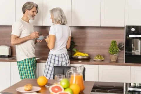 Married couple taking breakfast in the kitchen Stock Photos