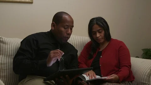 Married Couple Using and Electronic Tablet While Sitting on Sofa Stock Footage 110905688