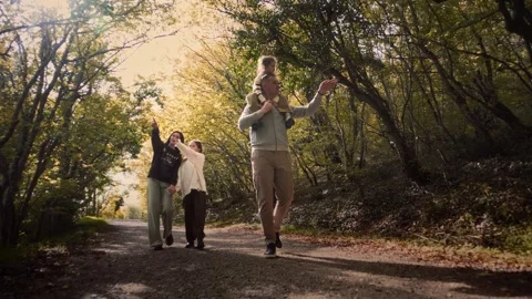 Married couple walking along a forest road with their happy little children. Stock Footage 307595298