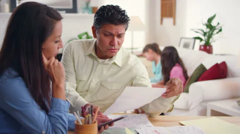 A married couple work together on bills while their kids do homework Video stock 34011885