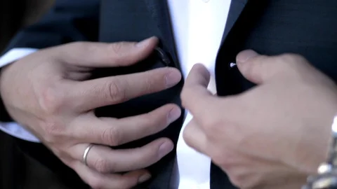 Married guy with wedding ring fastens button on blue jacket Stock Footage 119762408