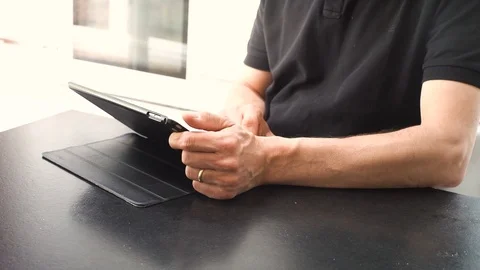Married Man browsing tablet in a modern kitchen flooded with sunlight. Stock Footage 108589946