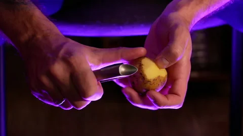 A married man peels potatoes with a vegetable peeler Video stock 165569653