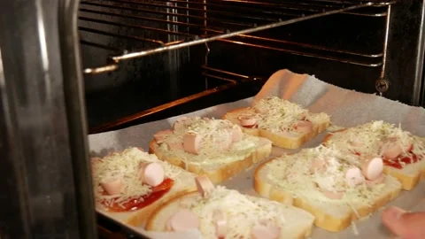 Married man with wedding ring pushing homamed sandwiches to the hot oven Video stock 139688807