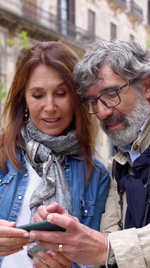 Married senior couple using gps on mobile phone looking for a location at city. Stock Footage 290778676