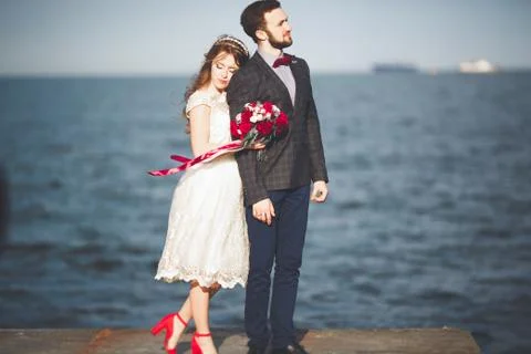 Married wedding couple standing on a wharf over the sea Stock Photos