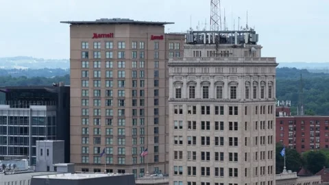 Marriott hotel tower with rooftop antenna array stands beside ornate historic 库存影片 344099197