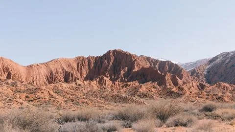 Mars Canyon red sandstone cliffs and desert shrubs landscape in Kyrgyzstan Stock Photos