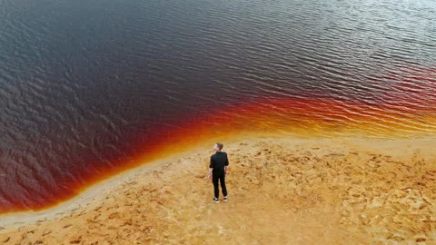 Mars planet Young man is walking in amazing red lake Ural Mars Stock Footage 158074356