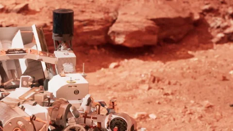 Mars rover exploring the surface of Mars under a clear sky Stock Footage 343931618