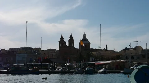 Marsaxlock against sun - hyperlapse with clouds, boats and people motion Stock Footage 63911769