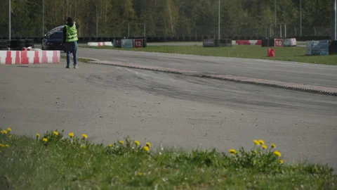 Marshal in protective vest waves checkered flag on track Mitsubishi Lancer Evo. Stock Footage 240981609