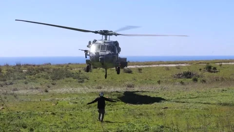 Marshaller directing U.S. Navy MH-60 Seahawk helicopter during takeoff Stock Footage 267958280