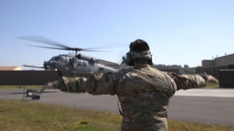Marshaller signalling to pilot of HH-60 Pave Hawk during take off Stock-Footage 108378932
