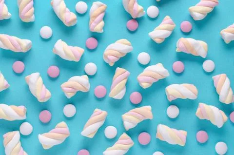 Marshmallow and candy, abstract pattern on blue background, top view Stock Photos