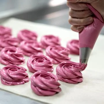 Marshmallow cooking process. Chef squeezes pink rose shaped Marshmallows out of Stock Photos