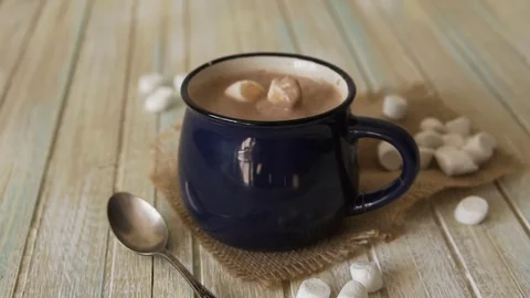 Marshmallow falls into a cup of cocoa and drops on the table Stock Footage 80976886