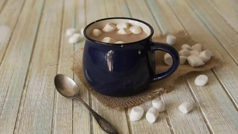 Marshmallow falls into a cup of cocoa and drops on the table Stock Footage 82673467