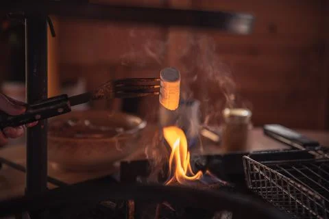 Marshmallow on a fork fried over a fire Stock Photos
