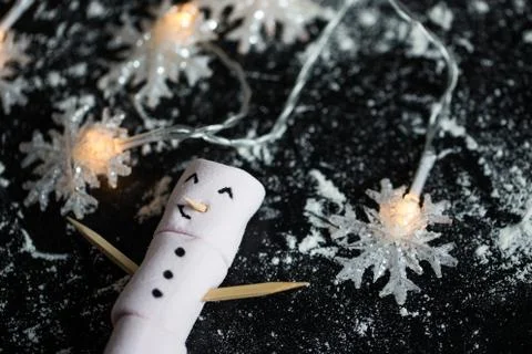 Marshmallow snow man with snowflake shape Christmas lights. Stock Photos
