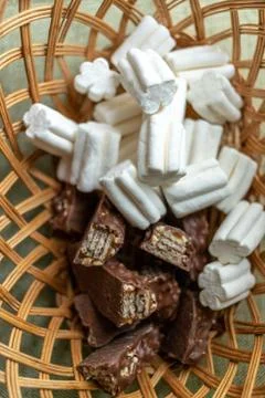 Marshmallows and chocolate lie in the same wicker basket 스톡 사진
