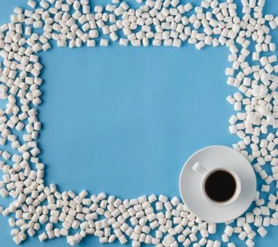 Marshmallows on blue background with copyspace and coffee cup. Flat lay or .. Stock Photos
