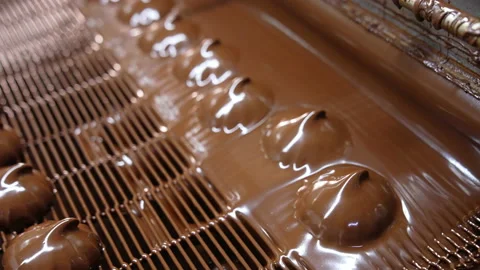 Marshmallows coming out from a thick layer of black melted chocolate.  Stock Footage 168642170