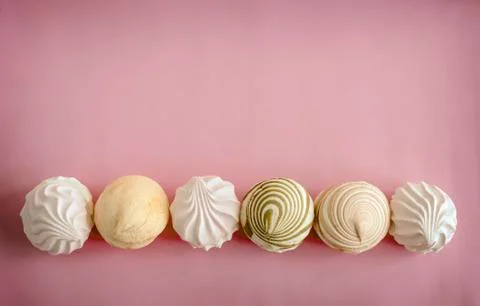 Marshmallows of different varieties on a pink background. Stock Photos
