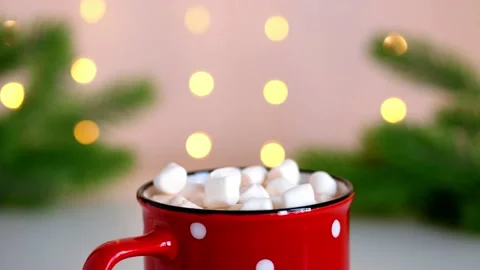 Marshmallows fall into red mug with hot chocolate. Flickering bokeh lights. Slow Stock Footage 167682851