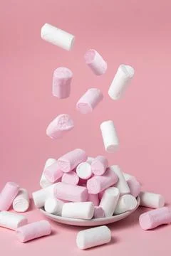 Marshmallows on a pink background. Marshmallows fall on a plate with marshmallow Stock Photos