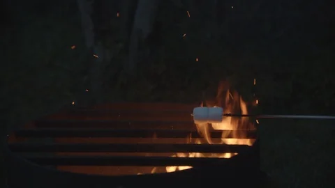 Marshmallows roasting on a Campfire with flames and sparks in slow motion, 4k 動画素材 112895989