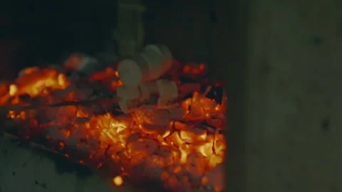 Marshmallows roasting over glowing hot coals on an outdoor BBQ, capturing the Stock Footage 345806348