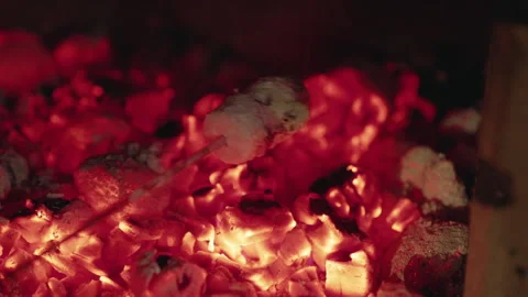 Marshmallows roasting over glowing hot coals on an outdoor BBQ, capturing the Stock Footage 345806394