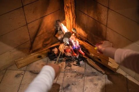 Marshmallows On Stick Roasting Over Campfire On Black Background. People take Stock Photos