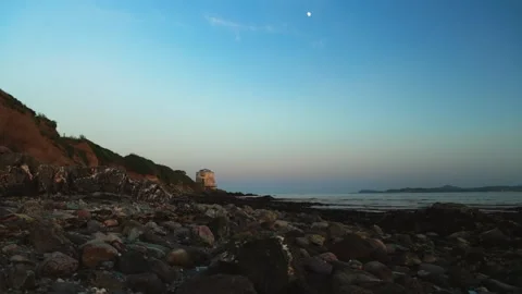 Martello Tower at Sutton viewed from a rocky beach during low tide beneath the Vídeo Stock 336745628