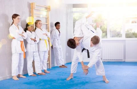 Martial arts master demonstrating throwing technique in sparring with teenager Stock Photos