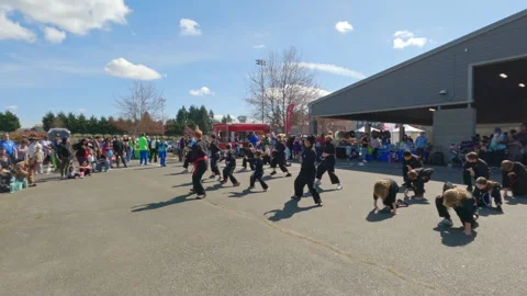 Martial arts students practicing synchronized forms on asphalt at an evegarden 9 Stock Footage 340310321