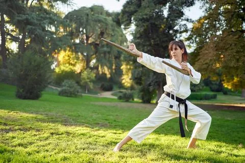 Martial arts teacher in white kimono is practicing with tonfa. Stock Photos