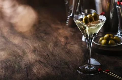 Martini cocktail, with dry vermouth, vodka and green olives, vintage wood bar Stock Photos