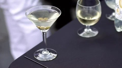 Martini with olives set on a table outside Stock Footage 78108539