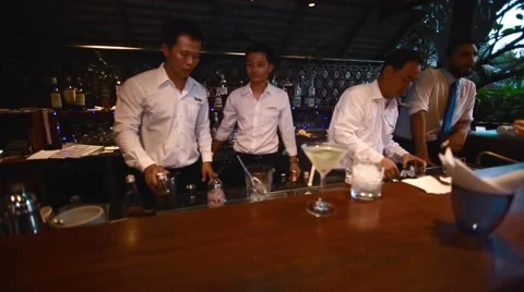 Martini sits on the bar while bartenders mix drinks Stock Footage 68078892