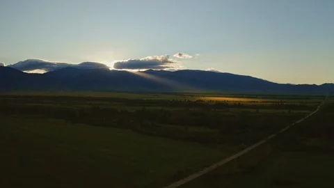 Marvelous sunrise, sun rays breaks through clouds, golden spotlight on dark land Stock Footage 126364322