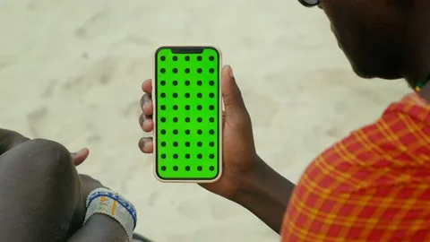 Masai Tribe Men Looking at the Smartphone and Touching Green Screen in the Front Stock Footage 189811642