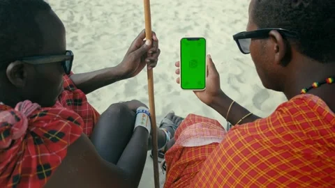 Masai Tribe Men Looking at the Smartphone Green Screen in the Front of Desert Stock Footage 193585634