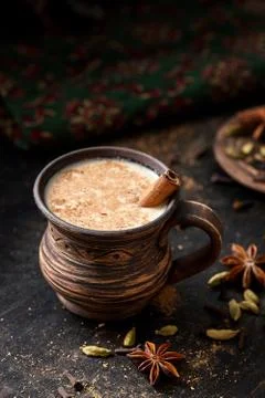 Masala pulled tea chai latte hot Indian sweet milk spiced drink, cinnamon stick Stock Photos