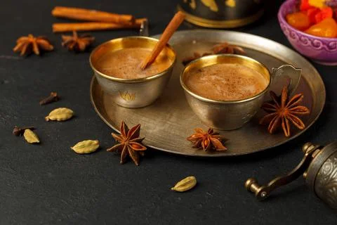 Masala tea in small serving copper cups, on a tray, close-up with star anise Stock Photos