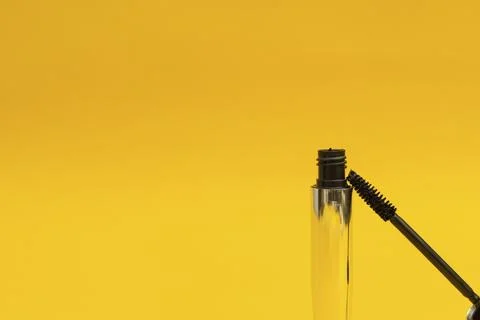 Mascara in silver package with yellow background Stock Photos