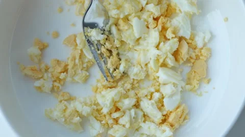 Mashed Boiled Eggs with Fork in White Bowl for Sandwich Preparation 스톡 동영상 343733695