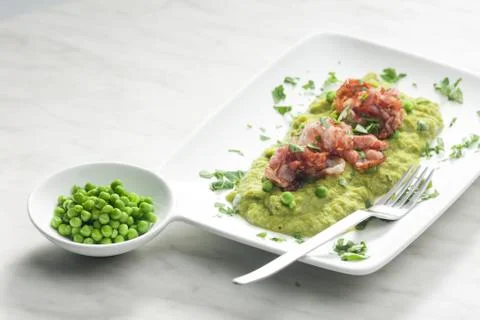 Mashed peas with fried pancetta Foto stock