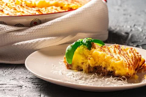 Mashed potato and ground beef casserole on a white plate with Parmesan cheese Stock Photos